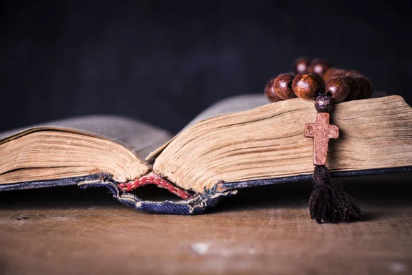 Rozenkrans op de Bijbel op een houten achtergrond. Heilig boek. — Stockfoto