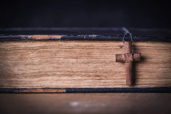 Croce marrone sulla Bibbia su uno sfondo di legno. Libro sacro . — Foto Stock