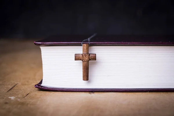 Коричневый крест на Библии на деревянном фоне. Священная книга . — стоковое фото