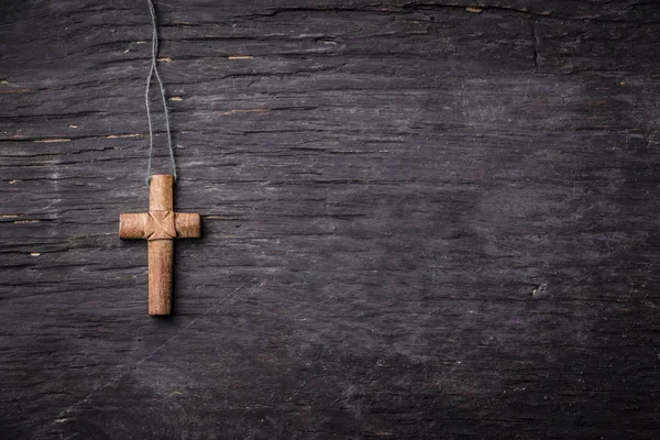 Cruz marrón sobre fondo de madera negro — Foto de Stock