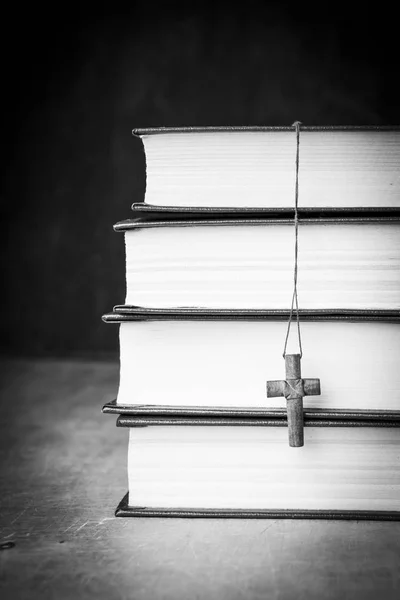 Croce sulla Bibbia su uno sfondo di legno. Santo cielo. Fotografia in bianco e nero — Foto Stock