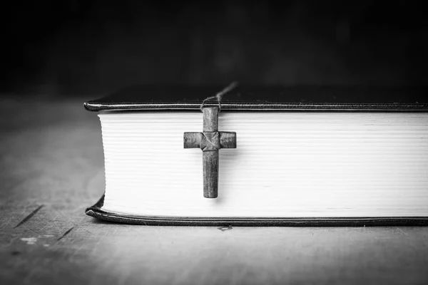 Cross på Bibeln på en trä bakgrund. Heliga bok. Svartvitt fotografi — Stockfoto