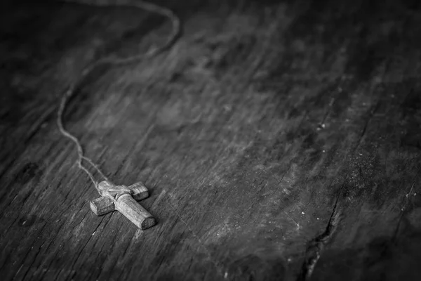 Cruz em um fundo de madeira preta. Fotografia em preto e branco — Fotografia de Stock