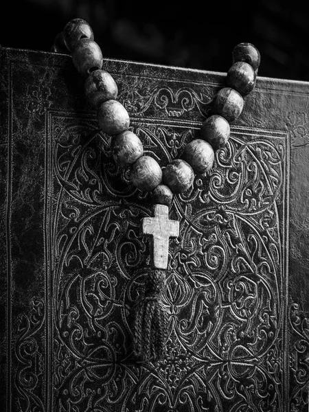 Rosary on the Bible on a wooden background. Holy book. Black and white photography — Stock Photo, Image