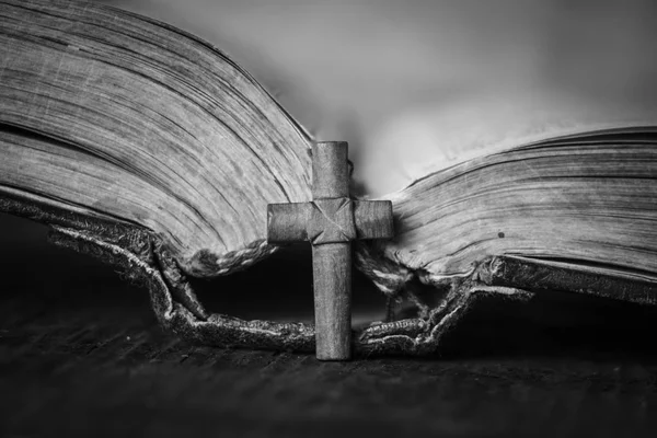 Cruza la Biblia sobre un fondo de madera. Libro sagrado. Fotografía en blanco y negro —  Fotos de Stock