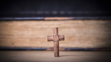 Ahşap arka plan üzerinde İncil üzerine kahverengi çapraz. Kutsal kitap.