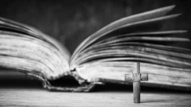 Ahşap arka plan üzerinde İncil üzerine çapraz. Kutsal kitap. Siyah beyaz fotoğraf