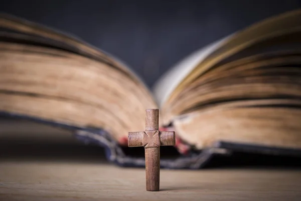 Croce marrone sulla Bibbia su uno sfondo di legno. Libro sacro . — Foto Stock