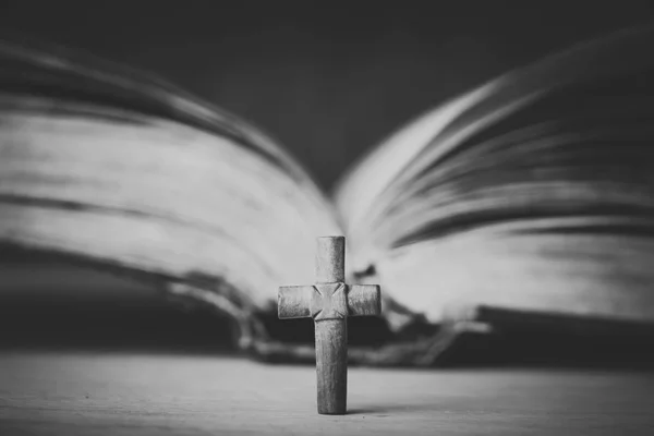 Cross on the Bible on a wooden background. Holy book. Black and white photography — Stock Photo, Image