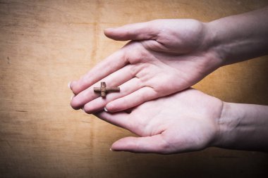 Kadın elinde bir ahşap arka plan üzerinde çapraz. 