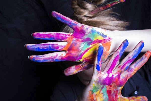 Der Künstler bedeckt sein Gesicht ihre Hände mit heller Farbe — Stockfoto