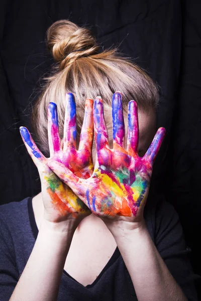 Der Künstler bedeckt sein Gesicht ihre Hände mit heller Farbe — Stockfoto