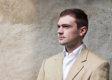 Duvar arka plan üzerinde takım elbiseli yakışıklı yiğit adam