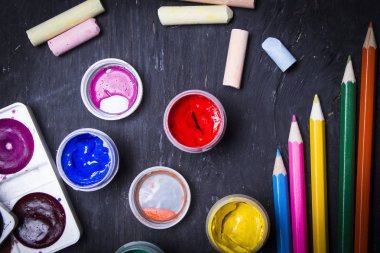 Parlak renkli boya, pastel, boya kalemi, kalem, fırça bir siyah ahşap arka plan üzerinde. Sanatçı için ayarlayın. Eğitim.