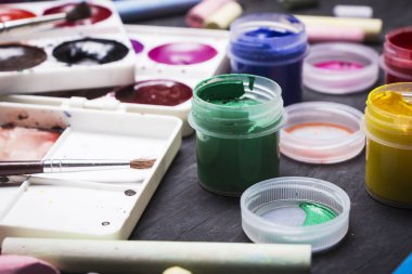 Parlak renkli boya, pastel, boya kalemi, kalem, fırça bir siyah ahşap arka plan üzerinde. Sanatçı için ayarlayın. Eğitim.