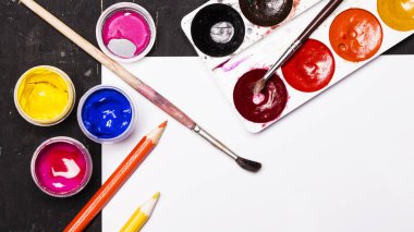 Parlak renkli boya, pastel, boya kalemi, kalem, fırça beyaz ve siyah ahşap zemin üzerinde. Sanatçı için ayarlayın. Eğitim.