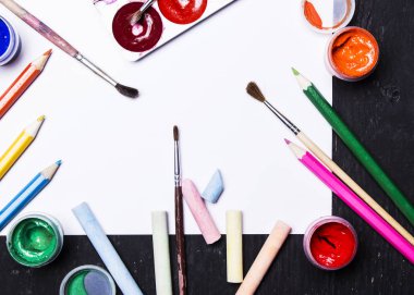 Parlak renkli boya, pastel, boya kalemi, kalem, fırça beyaz ve siyah ahşap zemin üzerinde. Sanatçı için ayarlayın. Eğitim.