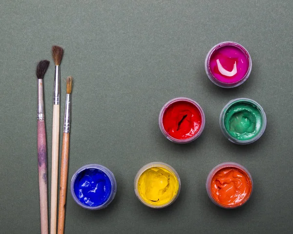 Pintura multicolor brillante, pinceles sobre fondo de madera negro. Listos para el artista. Educación . — Foto de Stock