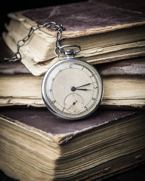 Relógio decadente no fundo de velhos livros sábios miseráveis . — Fotografia de Stock