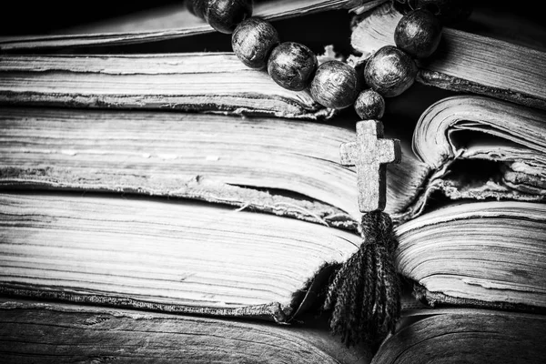Rosario sulla Bibbia su uno sfondo di legno. Santo cielo. Fotografia in bianco e nero — Foto Stock