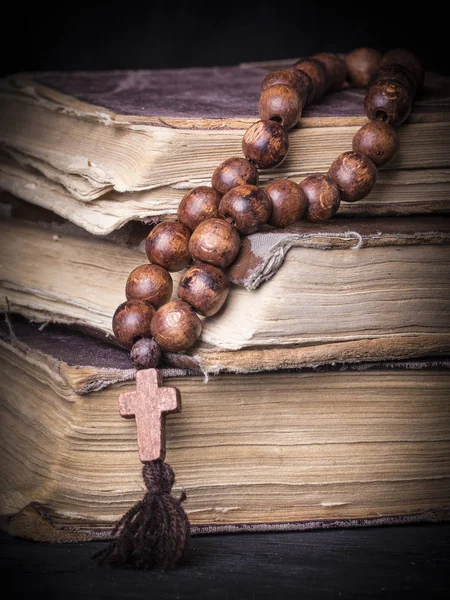 Rosário sobre a Bíblia sobre um fundo de madeira. Livro sagrado . — Fotografia de Stock