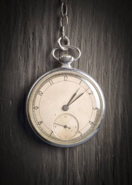 Koyu ahşap arka plan üzerinde eski bir zincir üzerinde antika saat