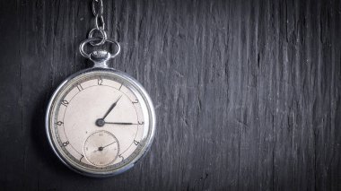 Koyu ahşap arka plan üzerinde eski bir zincir üzerinde antika saat