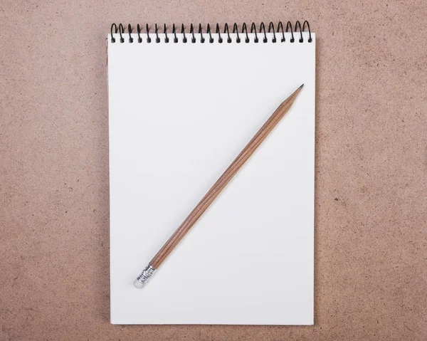 Open notepad with a pencil on a wooden background — Stock Photo, Image