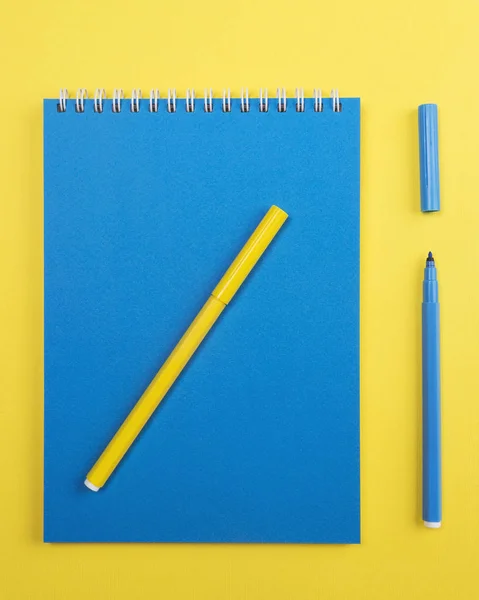 Notebook with markers. Yellow and blue colors — Stock Photo, Image