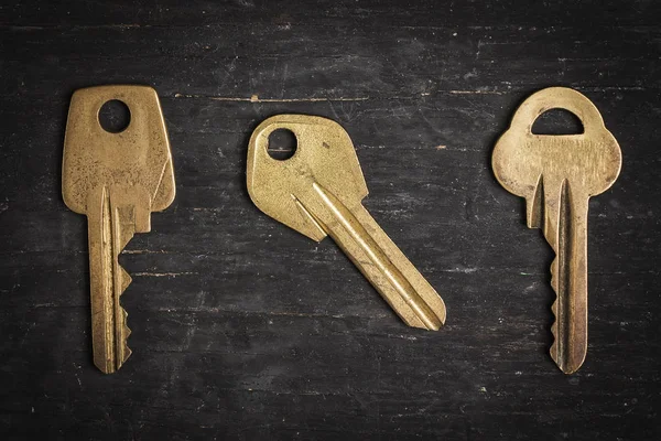 Old keys on a dark wooden background.