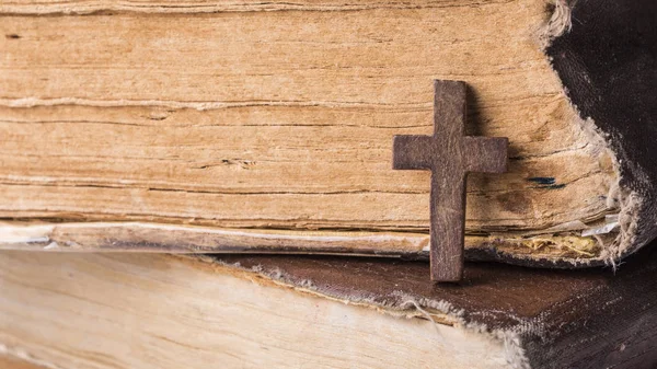 Cruz marrón en la Biblia sobre un fondo de madera. Libro sagrado . —  Fotos de Stock