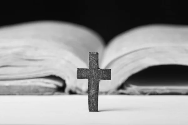 Krzyż na Biblii na tle drewnianych. Święta Księga. Fotografia czarno-białe — Zdjęcie stockowe