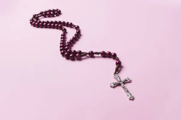 Rosário sobre fundo rosa. Cruz cristã . — Fotografia de Stock