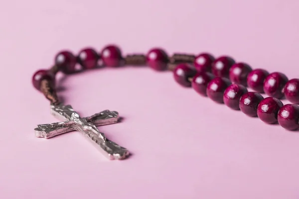 Rosario dengan latar belakang merah muda. Salib Kristen . — Stok Foto