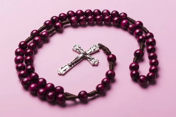 Rosario sobre fondo rosa. Cruz cristiana . — Foto de Stock