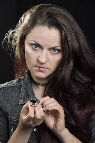 Retrato honesto de una chica con un labio roto sobre un fondo negro . — Foto de Stock