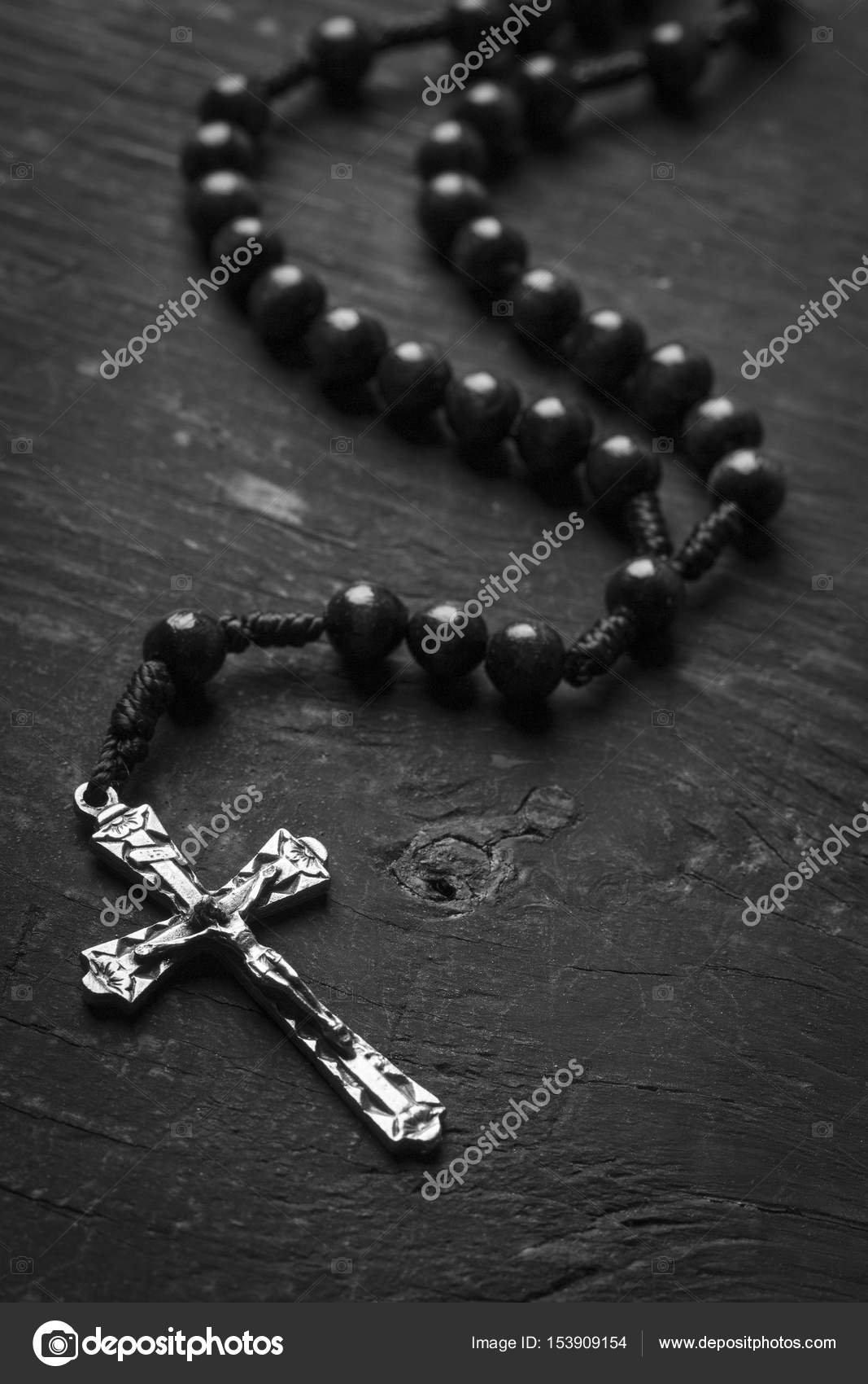 Rosary with a Christian cross on a monophonic background. Black and