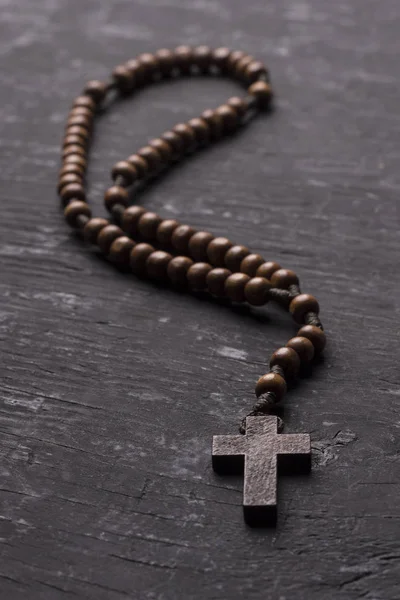 Rosaire avec une croix chrétienne sur un fond de bois sombre . — Photo