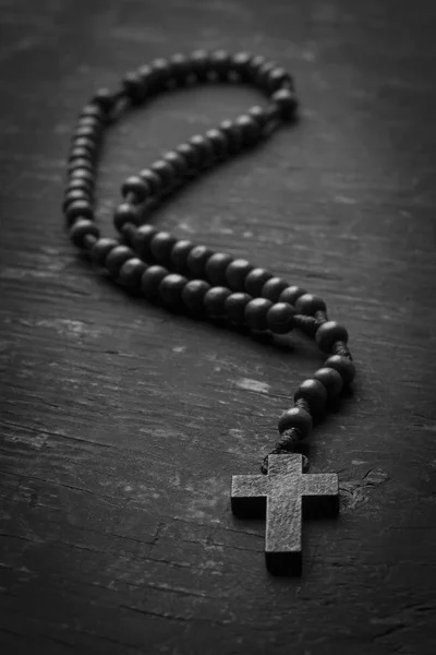 Rosário com uma cruz cristã em fundo monofônico. Fotografia em preto e branco . — Fotografia de Stock