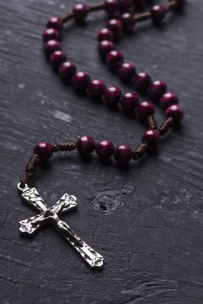 Rosaire avec une croix chrétienne sur un fond de bois sombre . — Photo