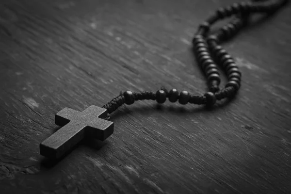 Rosario con cruz cristiana sobre fondo monofónico. Fotografía en blanco y negro . Fotos De Stock Sin Royalties Gratis
