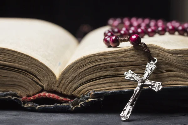 Rosenkransen och kors på Bibeln på en trä bakgrund. Helig bok. — Stockfoto