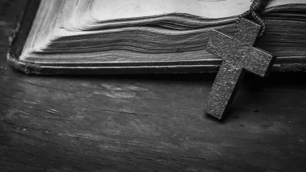 Rosary and  cross  on the Bible on a wooden background. Holy book. Black and white photography. — Stock Photo, Image