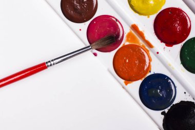 Çok renkli suluboya bir ışık gri arka plan üzerine bir fırça ile boyar. Nesneleri sanat için