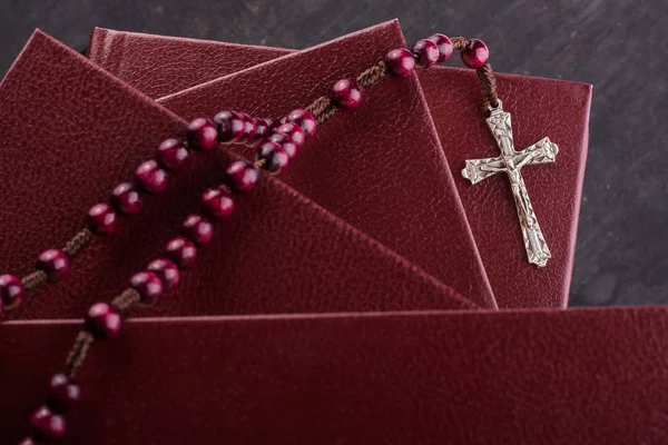 Rosenkransen och kors på Bibeln på en trä bakgrund. Helig bok. — Stockfoto