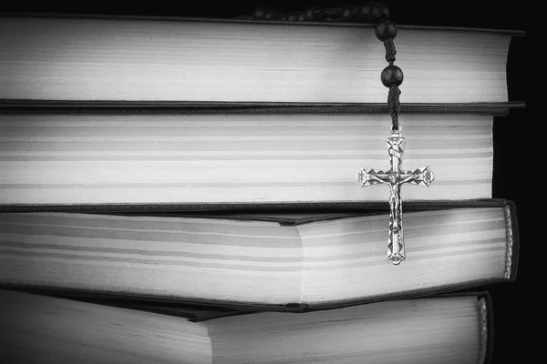 Różaniec i krzyż na Biblii na tle drewnianych. Święta Księga. Fotografia czarno-białe — Zdjęcie stockowe