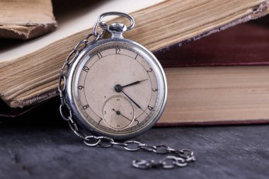 Eski püskü akıllıca kitap arka plan üzerinde çürüyen saat.
