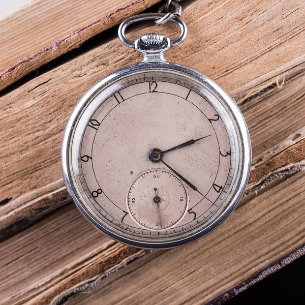 Гнилий годинник на тлі старих сліпих мудрих книг . — стокове фото