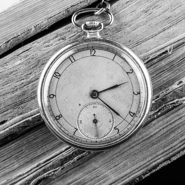 Reloj decadente en el fondo de viejos libros de mala calidad. Fotografía en blanco y negro —  Fotos de Stock