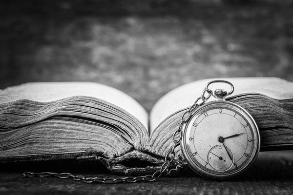 Reloj decadente en el fondo del viejo libro sabio. Fotografía en blanco y negro — Foto de Stock